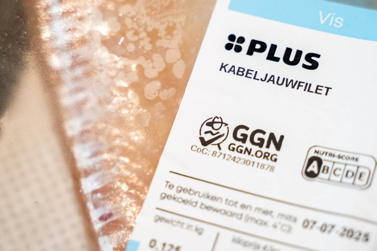 Close-up of a retail food pack label showing certification marks, weight and use-by date