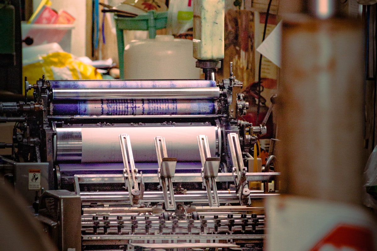 Inked cylinder rollers on a working flexographic press with the paper web running through