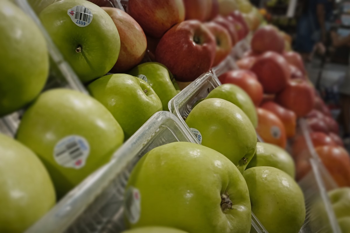 Apples in grocery clamshell packs carrying PLU stickers with barcodes