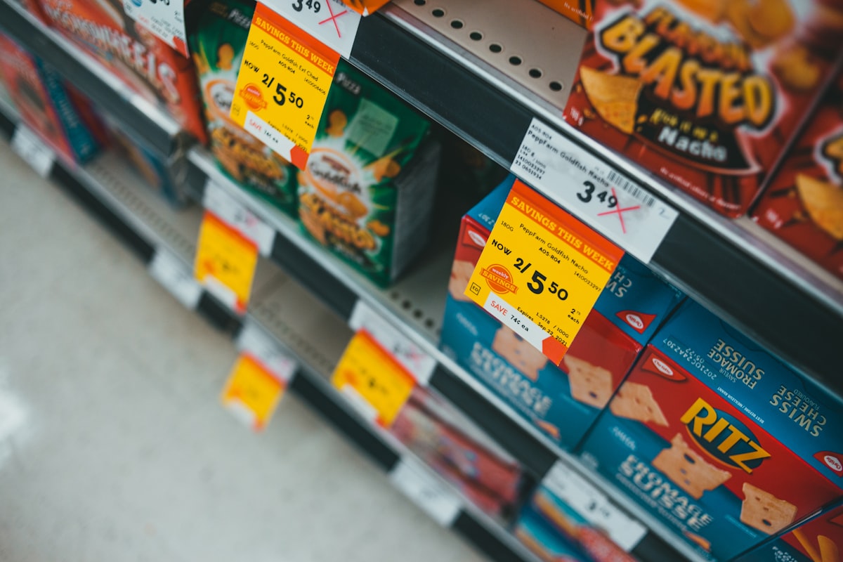 Supermarket shelf edge with promotional savings price labels and barcoded shelf tags